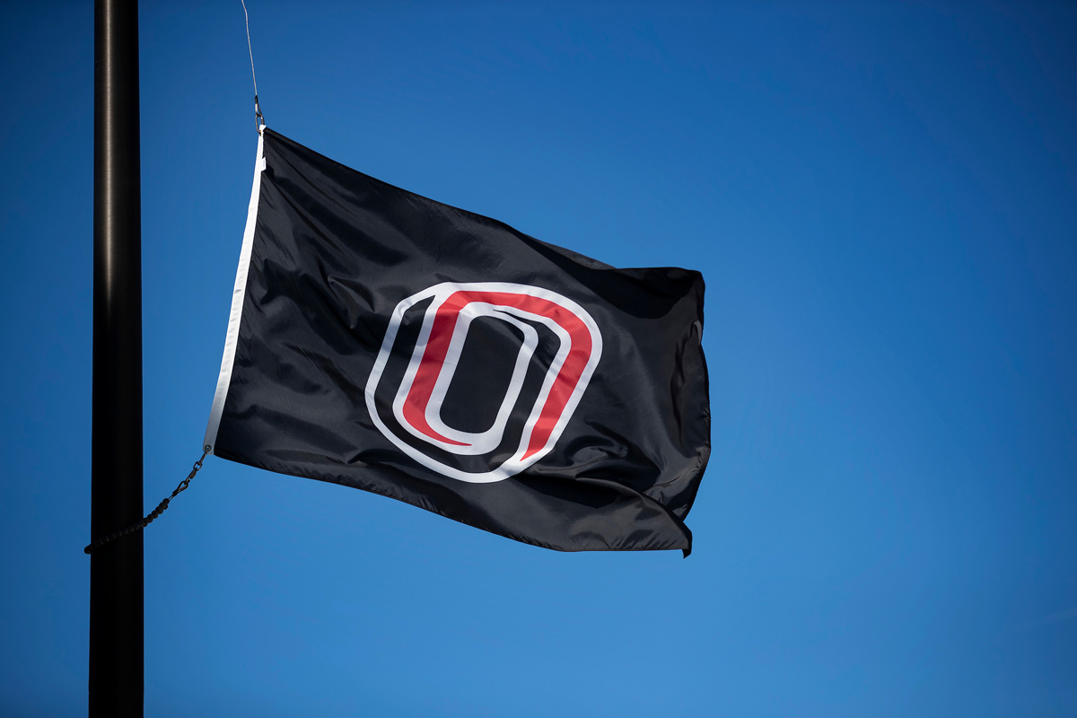 The UNO flag lowered, blowing in the breeze while on a flag pole.