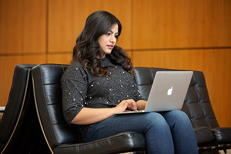 student typing on laptop